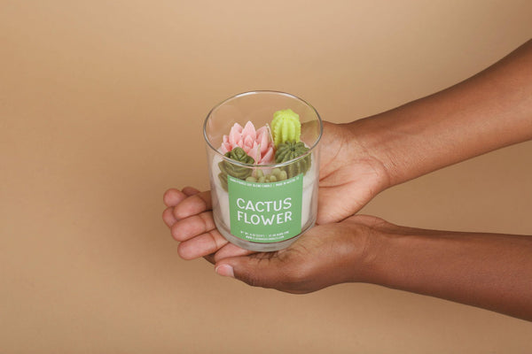 sculptural candle with cacti on top with label that reads cactus flower